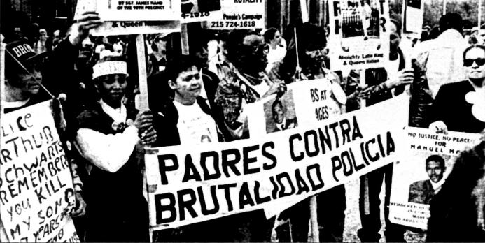 Immigrant rights rally; men holding sign: Padres contra brutalidad policia